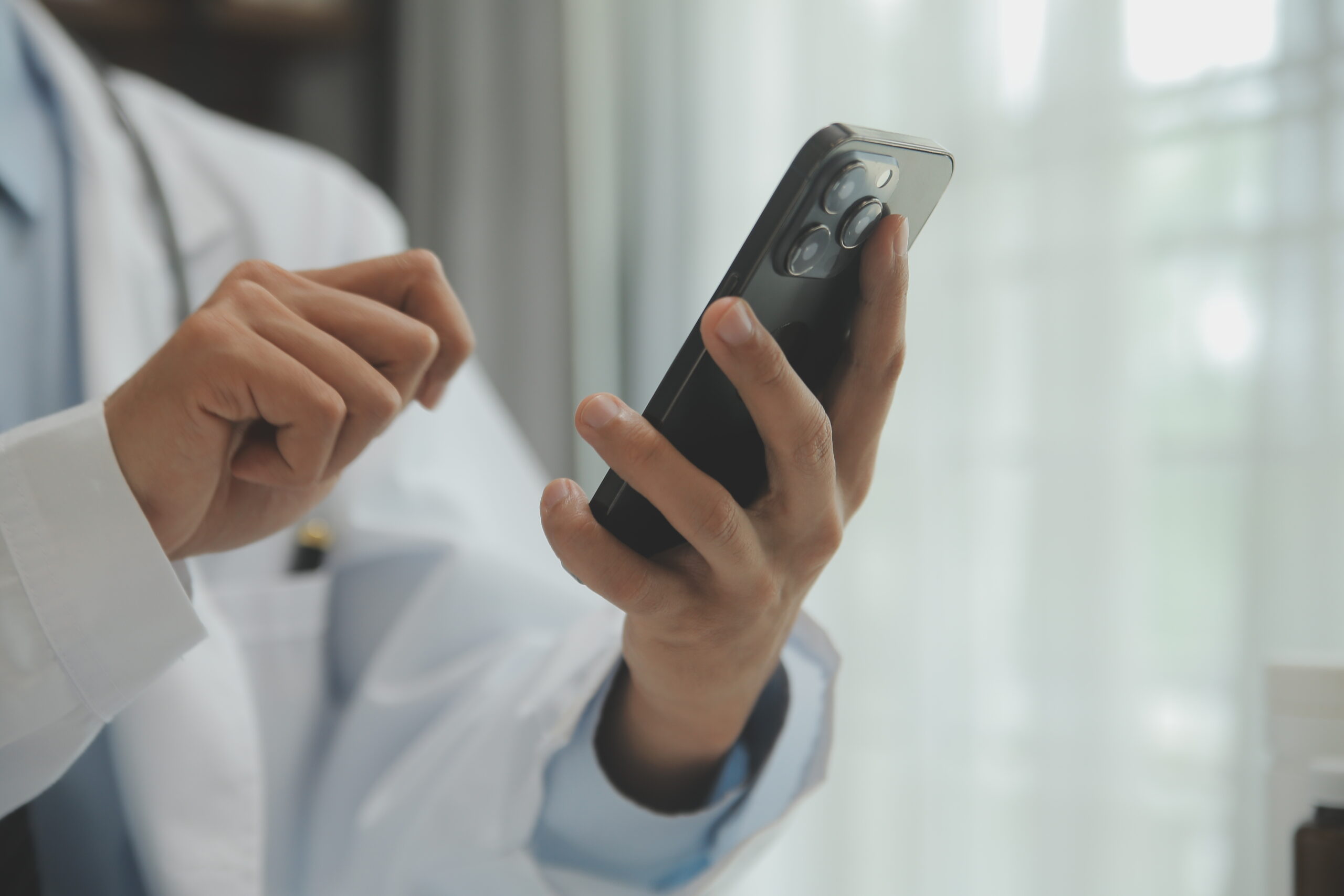 doctor using mobile phone for online pakistani medical exam preparation