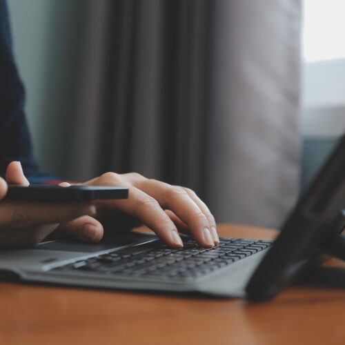 doctor preparing for FCPS Medicine theory exam using laptop and phone
