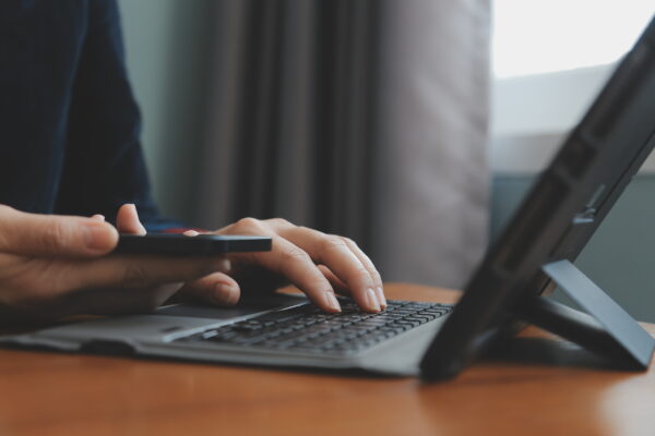doctor preparing for FCPS Medicine theory exam using laptop and phone